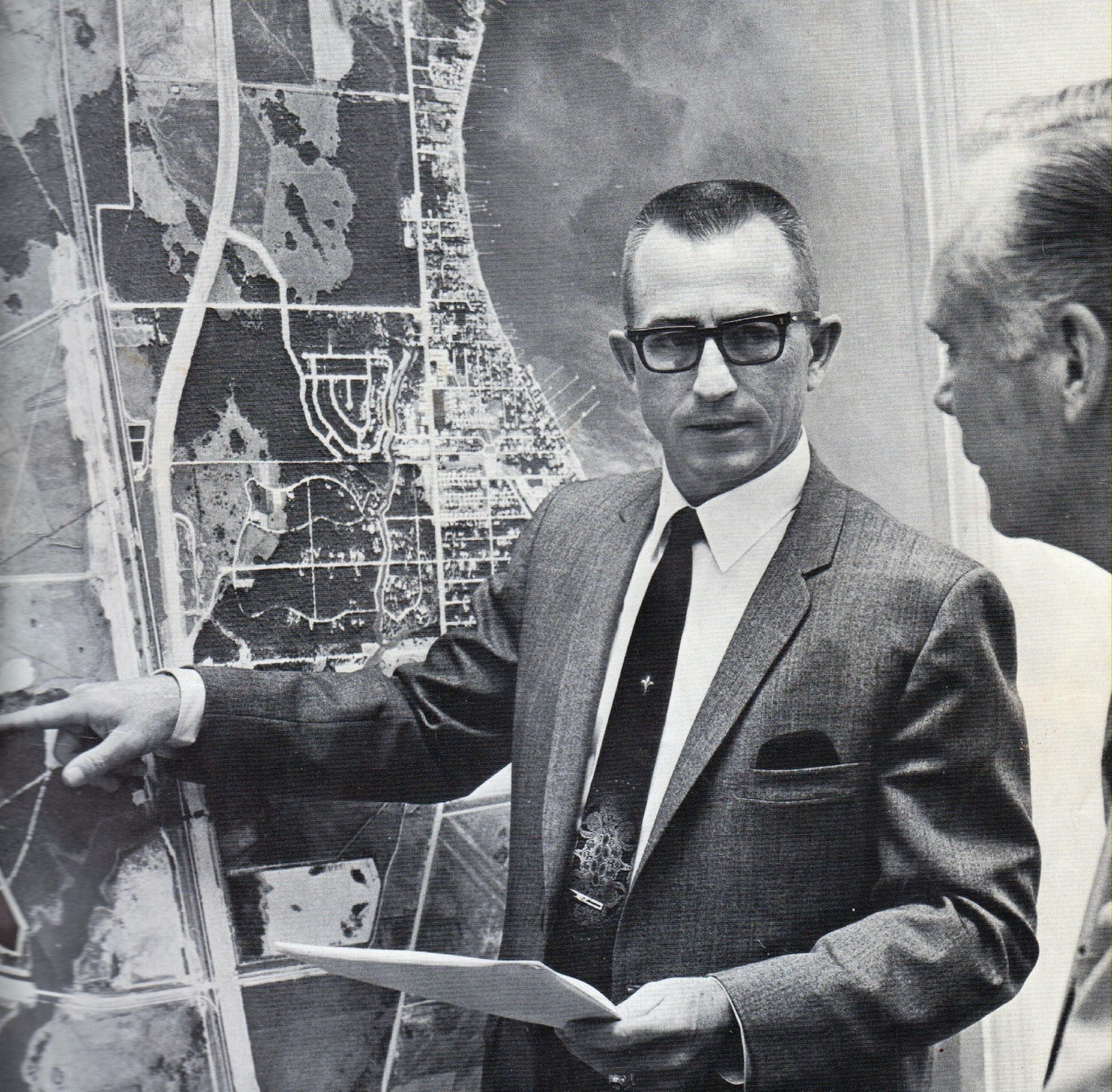 John D. Bruton, Jr., beside a community development map